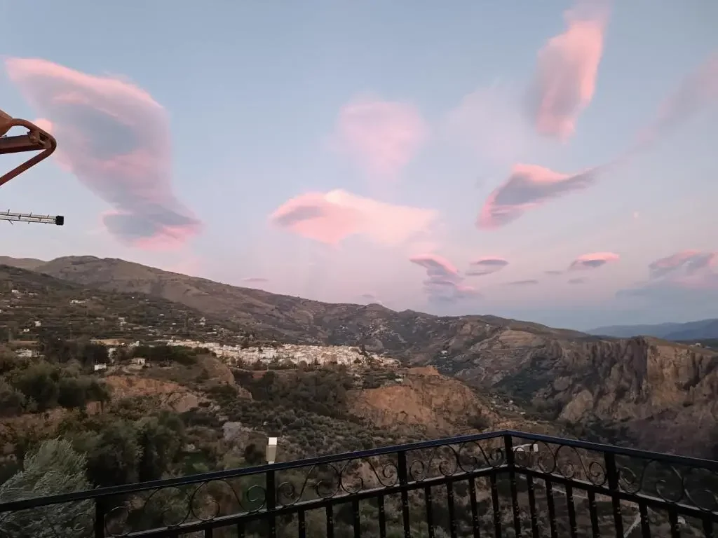 Cenas al aire libre Atardecer sobre montañas con nubes rosadas y paisaje natural.